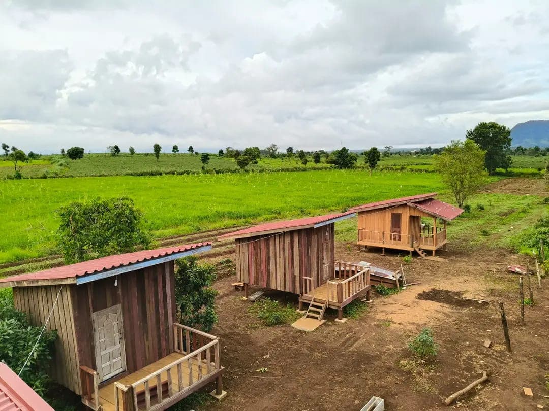 Traditional eco-friendly bungalow accommodation with shared facilities nestled among organic farm plots