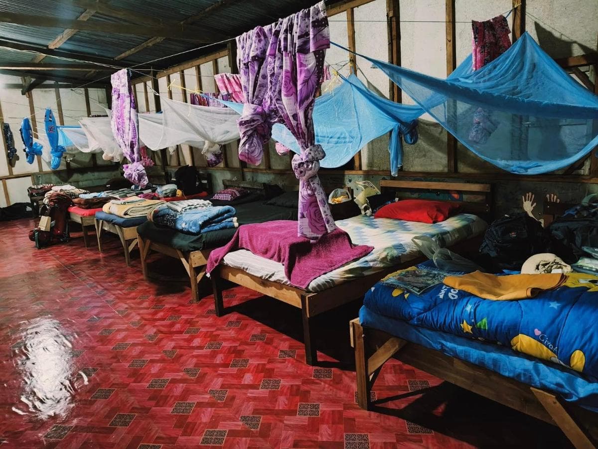 Budget-friendly dormitory with bunk beds for backpackers and volunteers in rustic farm setting